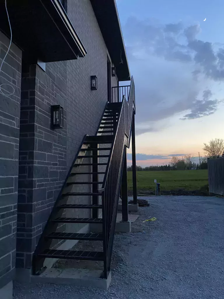 Black metal railing installed along an exterior staircase