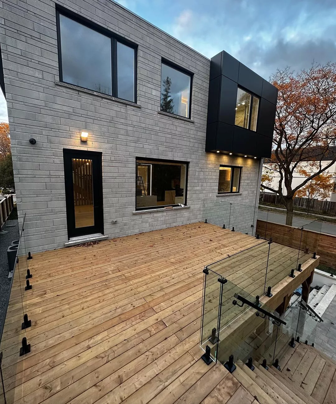Glass guard around a wood deck and exterior stair opening