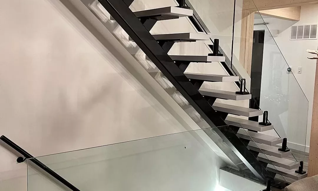 Modern staircase with black metal structure and clear glass railings